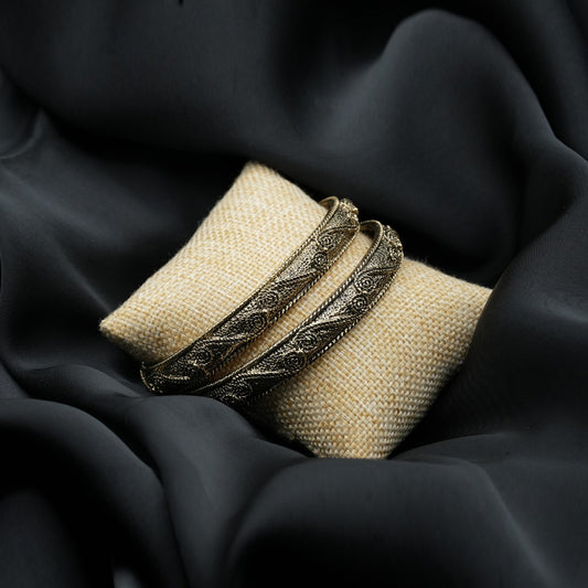 A pair of elegant bangles featuring an intricate antique-style design with fine filigree detailing, showcasing delicate floral and twisted rope patterns image 1