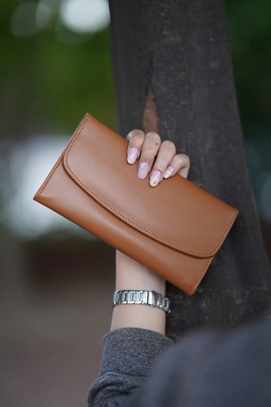 A Stylish and minimalistic genuine leather clutch with a smooth finish and curved flap design, perfect for any occasion image 0