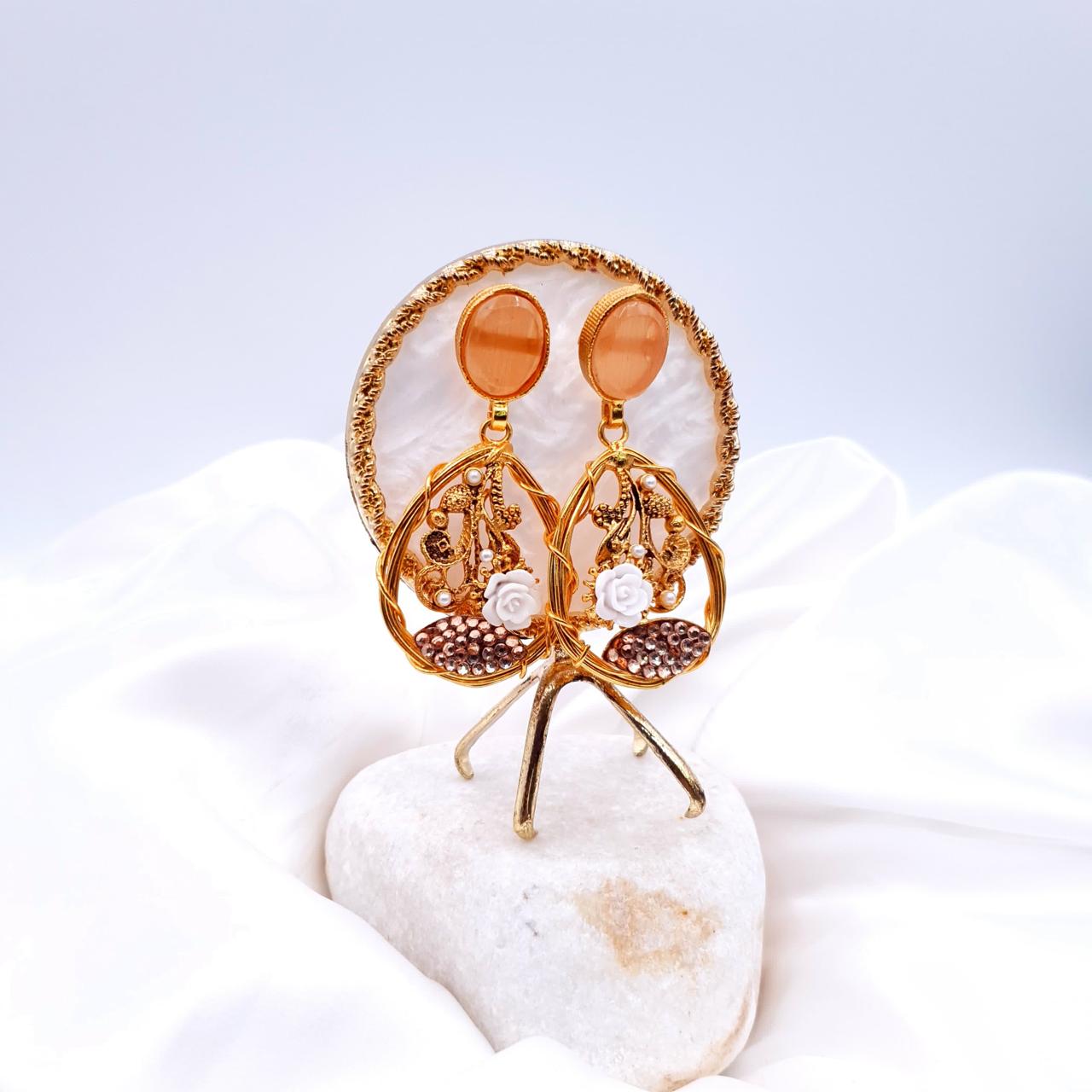 oval-shaped gemstone at the top, followed by a delicate gold frame with decorative swirls, tiny pearls, and a small rose image 2