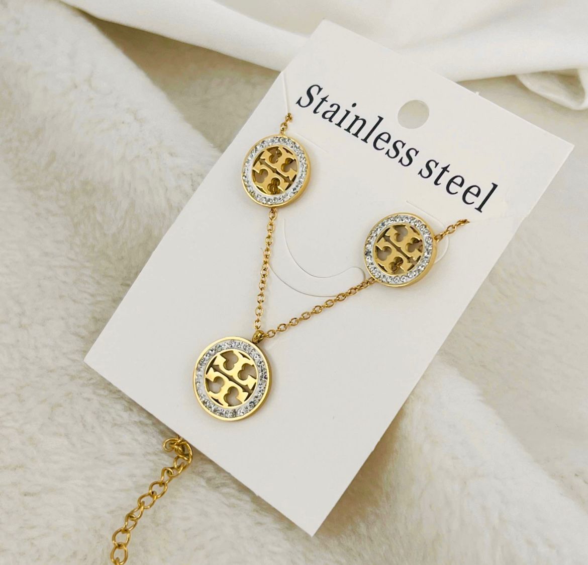 NEKLACE	Elegant and modern, this stainless steel set features a gold-tone necklace and matching earrings with a chic cut-out design. Tarnish-resistant and perfect for any occasion. image 1