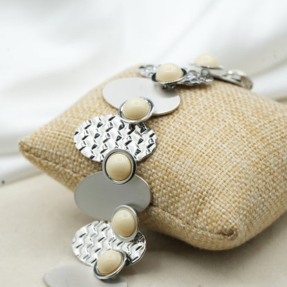 A contemporary mix of oval and circular metal elements in alternating textures image 1