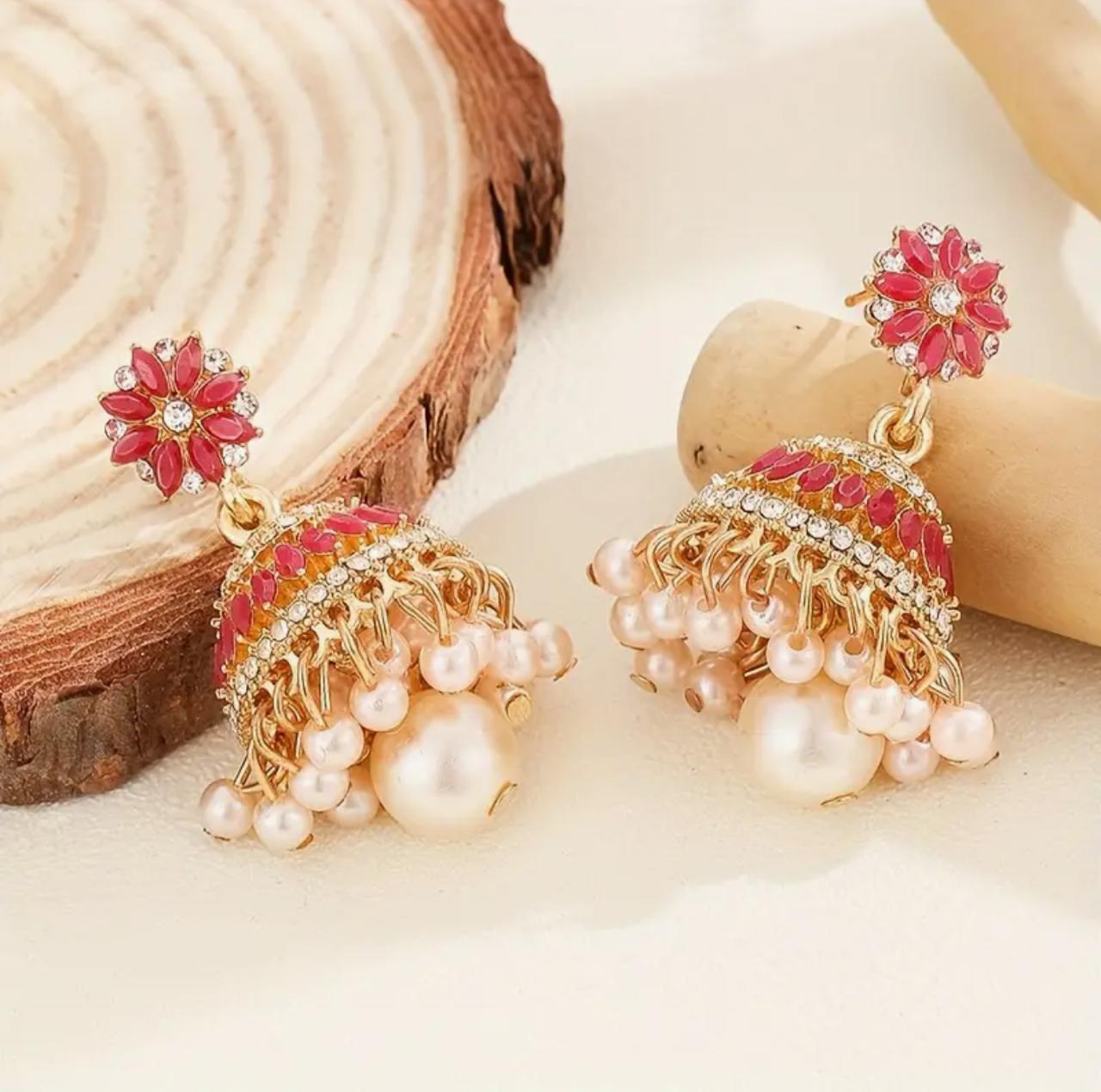 Elegant jhumka-inspired dangles adorned with a sparkling rhinestone flower, pink and gold bell accents, and imitation pearl tassels. Crafted from chic zinc alloy, ideal for daily wear, festive occasions, weddings, and parties image 1