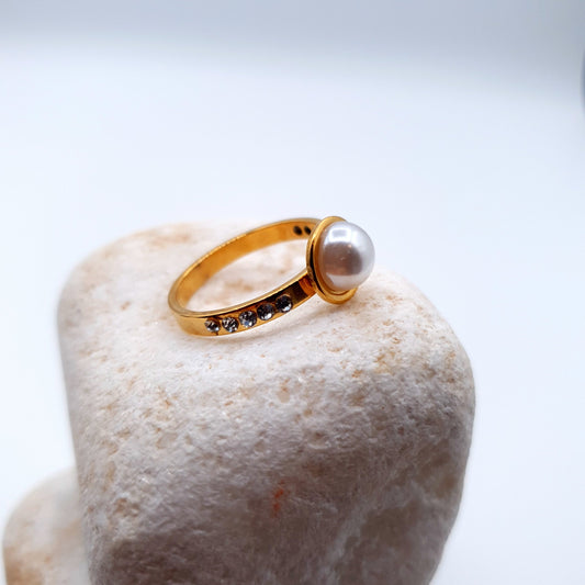 A stunning ring featuring a luminous pearl at the center, elegantly encircled by sparkling stones. image 0