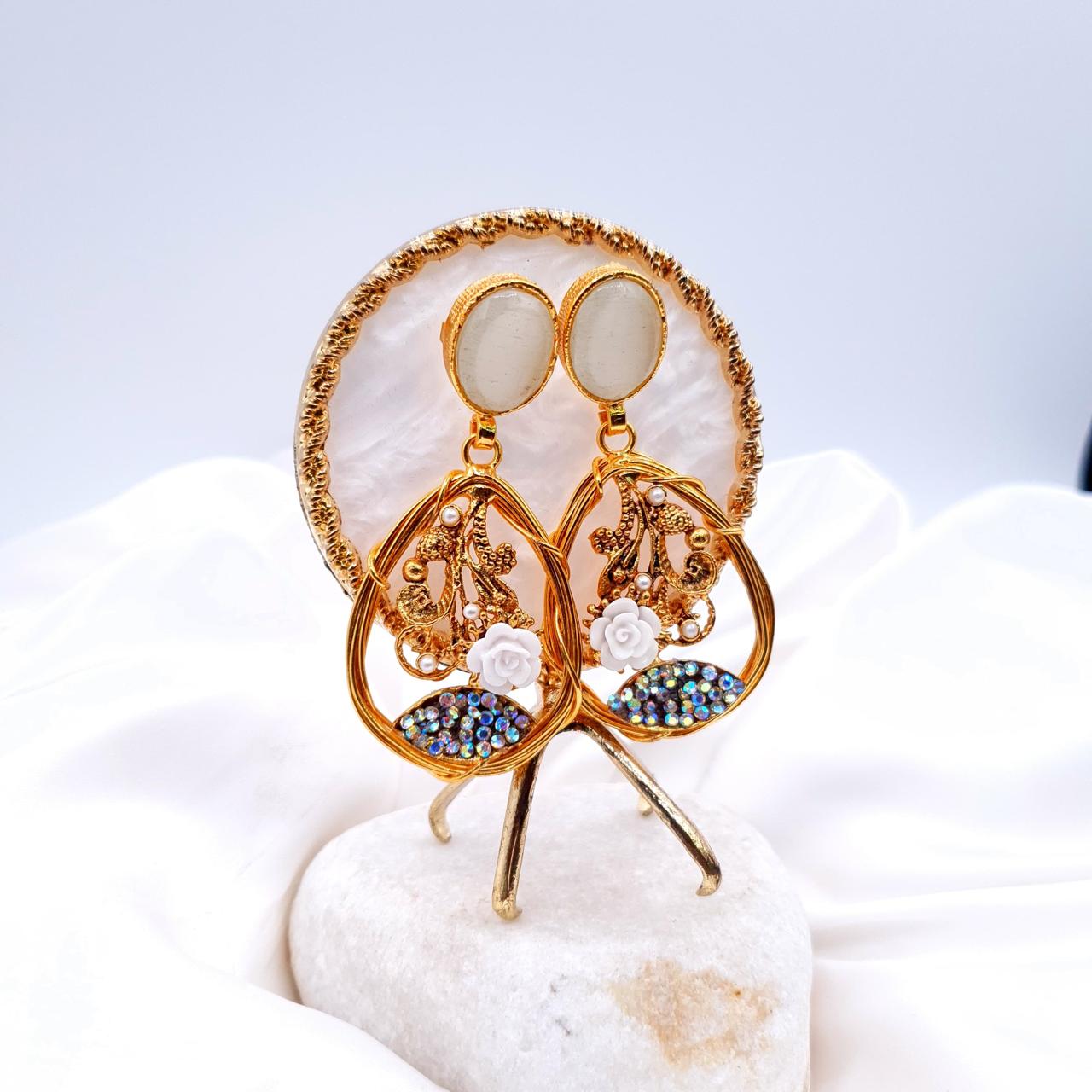 oval-shaped gemstone at the top, followed by a delicate gold frame with decorative swirls, tiny pearls, and a small rose image 3