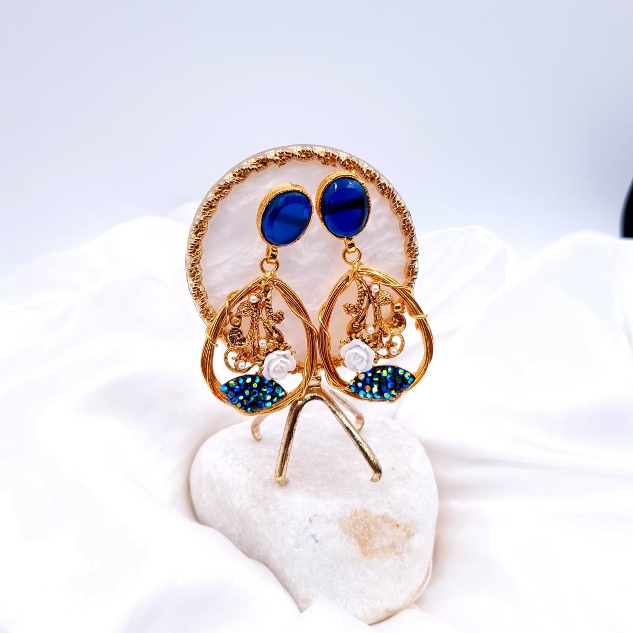 oval-shaped gemstone at the top, followed by a delicate gold frame with decorative swirls, tiny pearls, and a small rose image 4