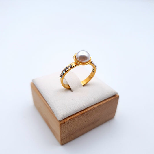 A stunning ring featuring a luminous pearl at the center, elegantly encircled by sparkling stones. image 1