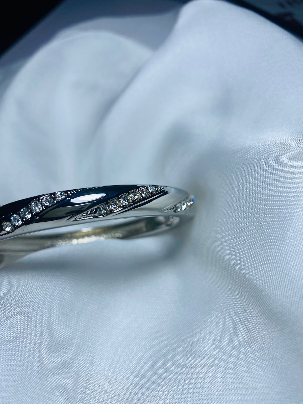Embellished with small, sparkling cubic zirconia stones along the curves, adding a touch of glamour