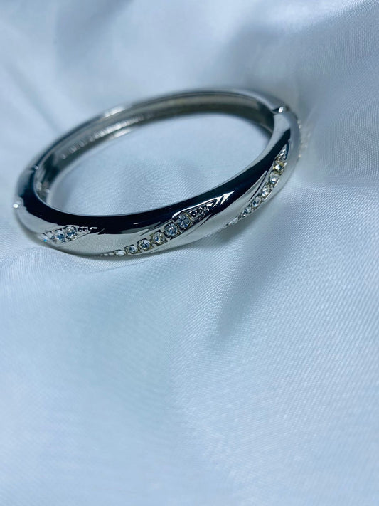 Embellished with small, sparkling cubic zirconia stones along the curves, adding a touch of glamour