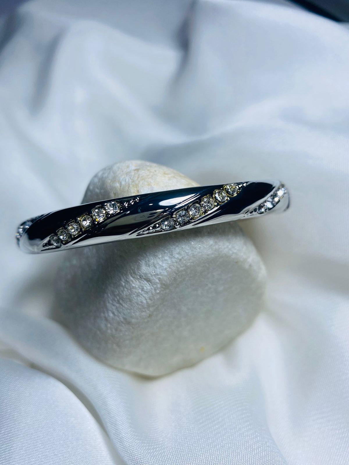 Embellished with small, sparkling cubic zirconia stones along the curves, adding a touch of glamour