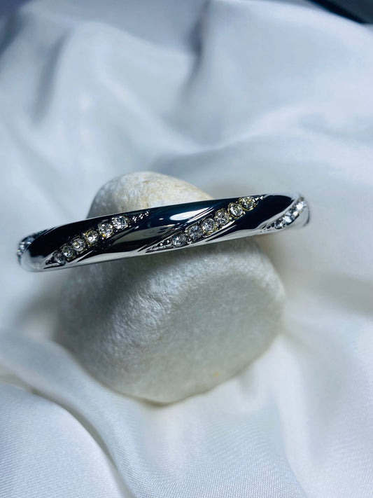 Embellished with small, sparkling cubic zirconia stones along the curves, adding a touch of glamour