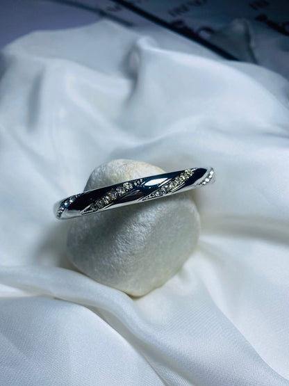 Embellished with small, sparkling cubic zirconia stones along the curves, adding a touch of glamour