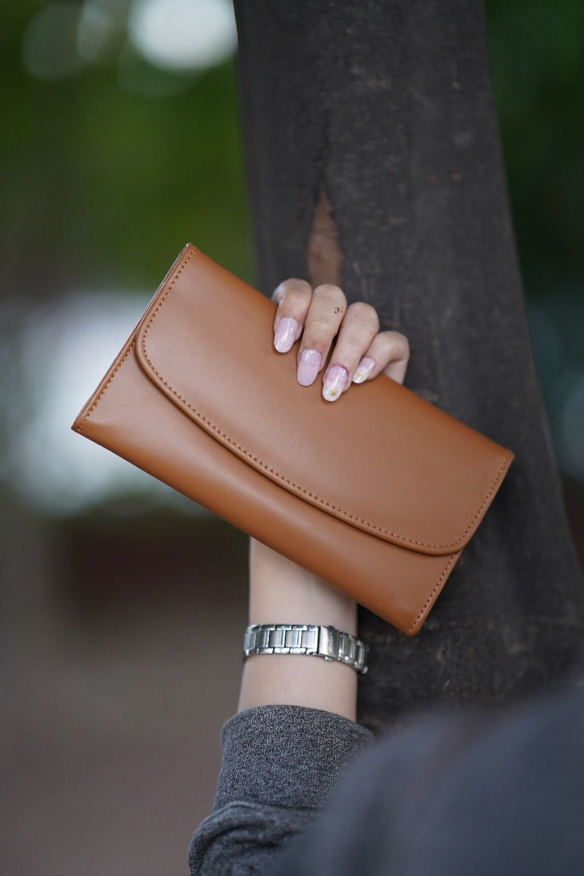 A Stylish and minimalistic genuine leather clutch with a smooth finish and curved flap design, perfect for any occasion image 0