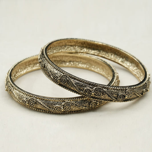 A pair of elegant bangles featuring an intricate antique-style design with fine filigree detailing, showcasing delicate floral and twisted rope patterns image 0